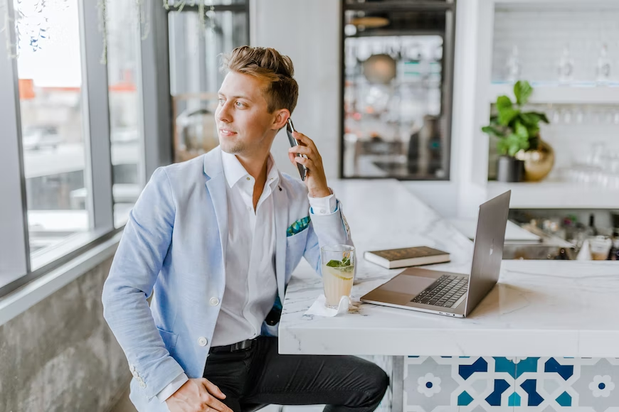 Homem dono de um Sociedade Limitada Unipessoal (SLU) sentado em seu escritório fazendo uma ligação pelo celular.