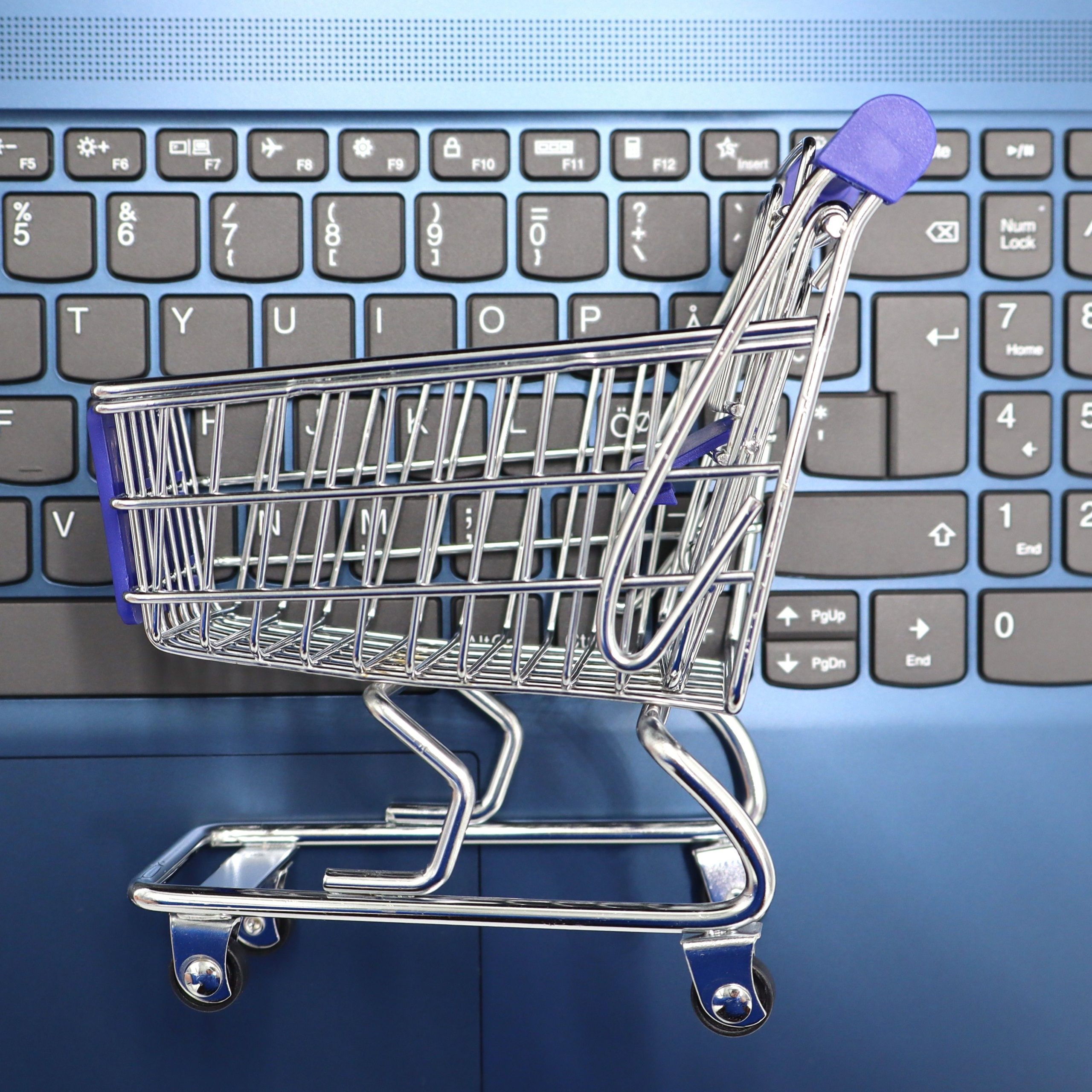 Carrinho em cima de um teclado representando as compras online